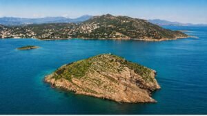 Εναέρια λήψη drone μικρού νησιού στο Πόρτο Ράφτη με καθαρά γαλάζια νερά και ακτογραμμή