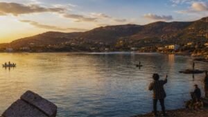 Ψαράδες στο Πόρτο Ράφτη την ώρα του ηλιοβασιλέματος με θέα τον κόλπο και τους λόφους της περιοχής. Απεικόνιση παλιάς εποχής.